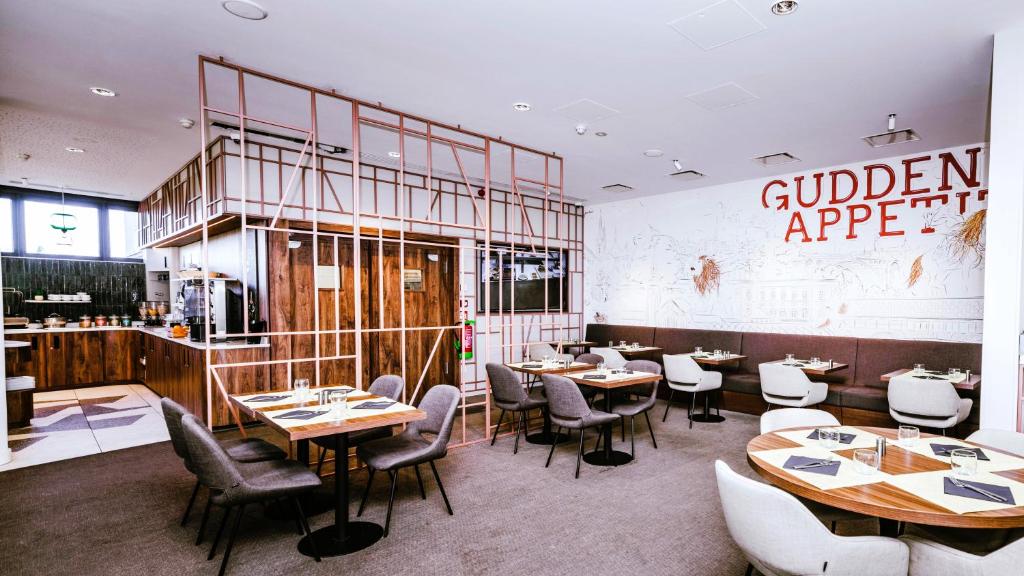 a restaurant with tables and chairs in a room at Ibis Luxembourg Airport in Luxembourg