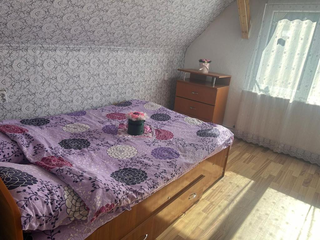 ein Schlafzimmer mit einem Bett mit einer lila Bettdecke in der Unterkunft Cabana Narcisa in Arpaşu de Sus