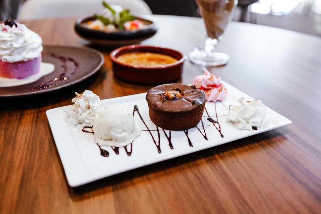 a plate of desserts on a wooden table at Ibis Luxembourg Airport in Luxembourg