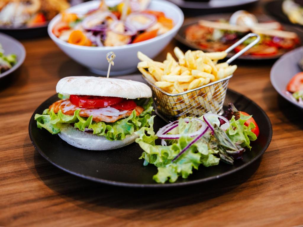 a plate of food with a sandwich and french fries at Ibis Luxembourg Airport in Luxembourg