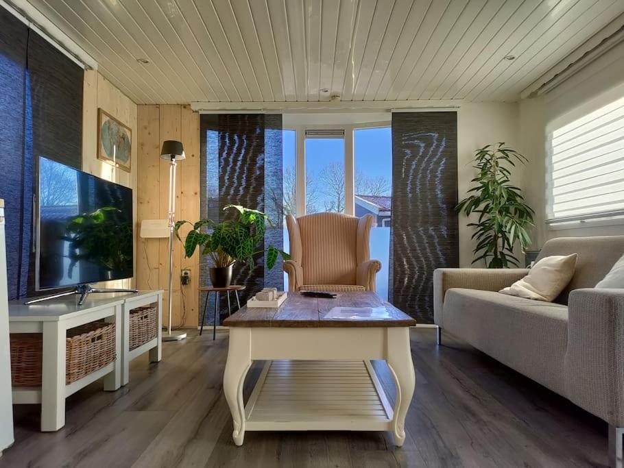 a living room with a couch and a table at Chalet midden in de natuur! in Anloo