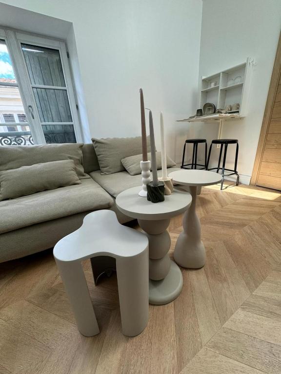 un salon avec un canapé et deux tables et chaises dans l'établissement La Halte des Arènes de Nîmes Nude Beauté du Minimalisme, à Nîmes