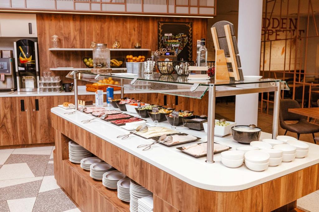a buffet in a restaurant with plates and food at Ibis Luxembourg Airport in Luxembourg