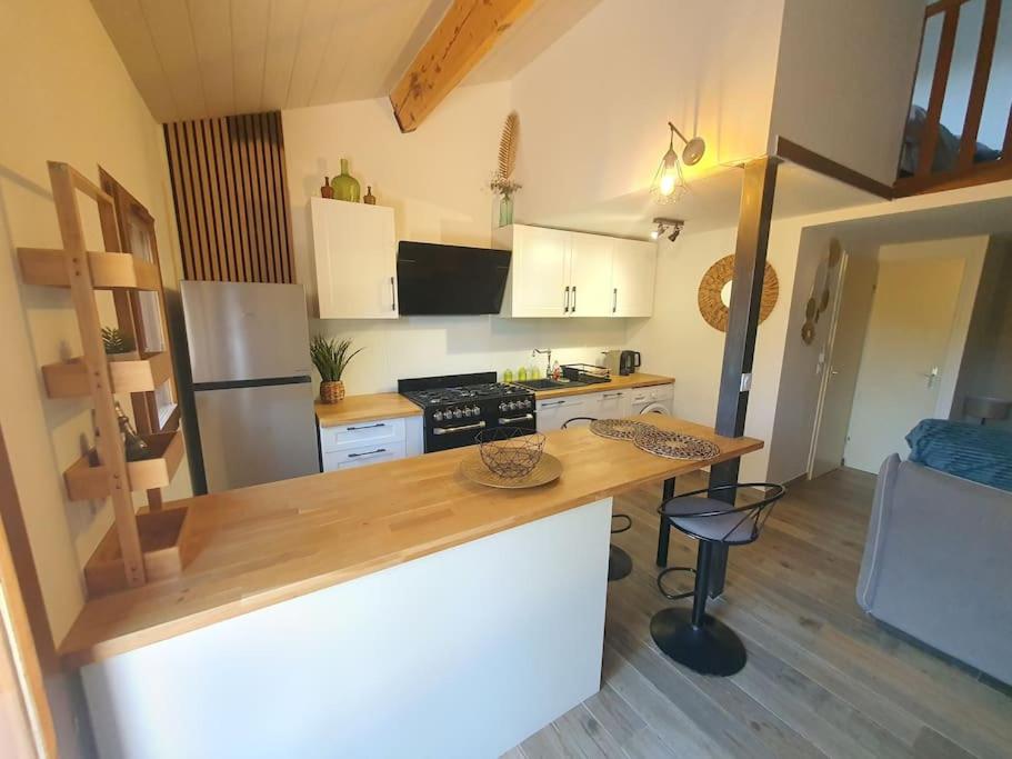 une cuisine avec un comptoir en bois dans une pièce dans l'établissement Charmante maison, à La Motte