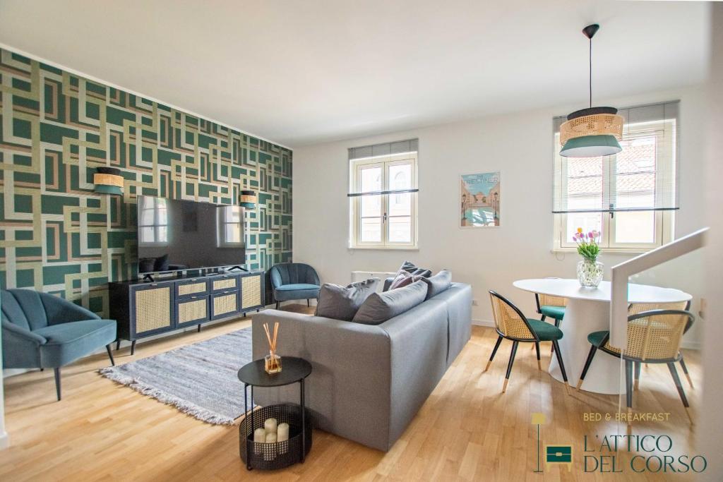 a living room with a couch and a table at L'Attico del Corso in Trieste