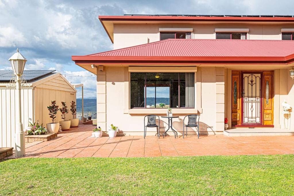 una casa con due sedie su un patio in mattoni di Goldfields View a One Tree Hill