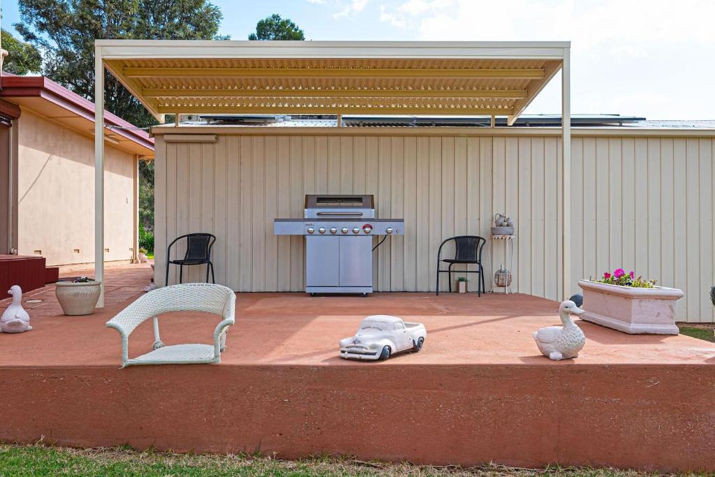 un patio con tavolo, sedie e griglia. di Goldfields View a One Tree Hill