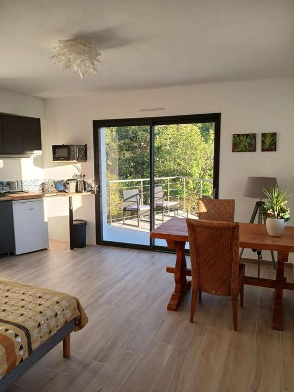 Il comprend un salon avec une table et une cuisine avec un balcon. dans l'établissement Domaine en pleine nature et tout près de la plage, à Sanary-sur-Mer