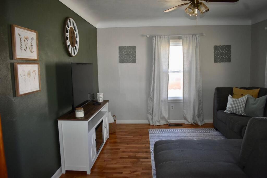 a living room with a couch and a window at Cozy Garden House in Adrian