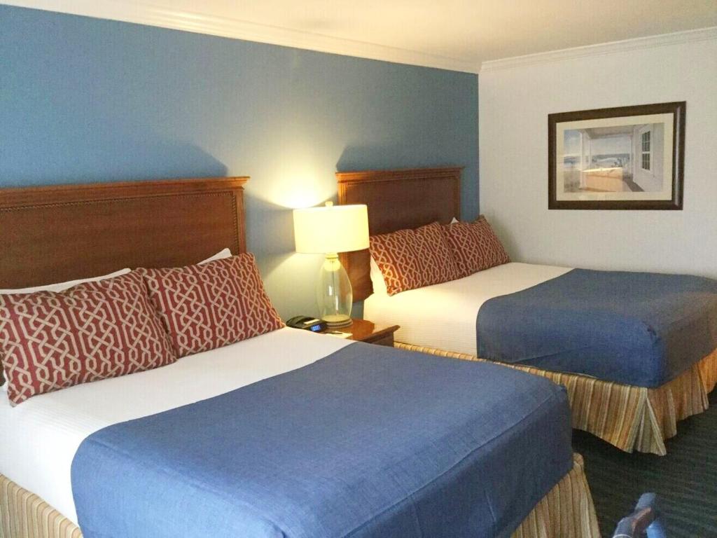 a hotel room with two beds and a lamp at Avenue Inn & Spa in Rehoboth Beach