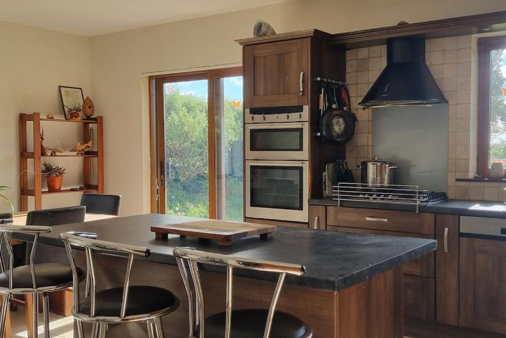 a kitchen with a table and some chairs in it at ocean fields view in Ahnagh Cross