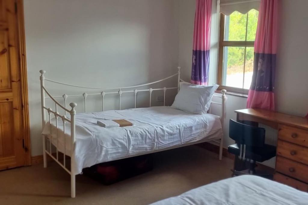a bedroom with a bed and a window at ocean fields view in Ahnagh Cross
