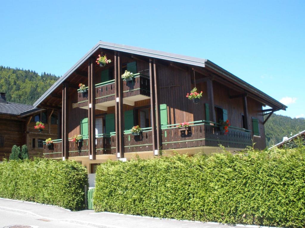 une grande maison en bois avec des fleurs sur le balcon dans l'établissement Chalet le Feufy, à Morzine
