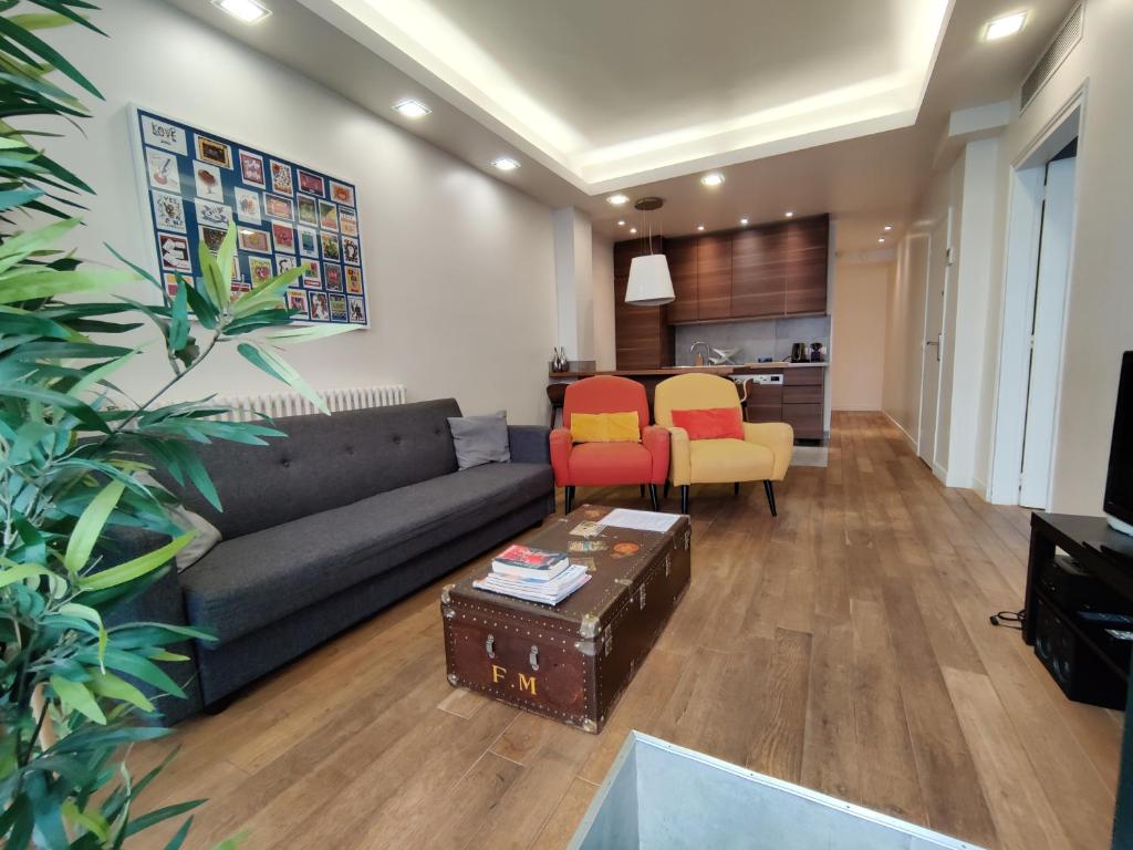 een woonkamer met een zwarte bank en oranje stoelen bij 3 double bedrooms apartment in Montmartre near subway AC in Parijs