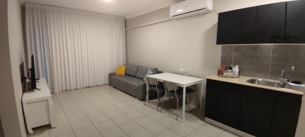 a kitchen with a couch and a table and a sink at Mediterranean Sea View in Ashqelon