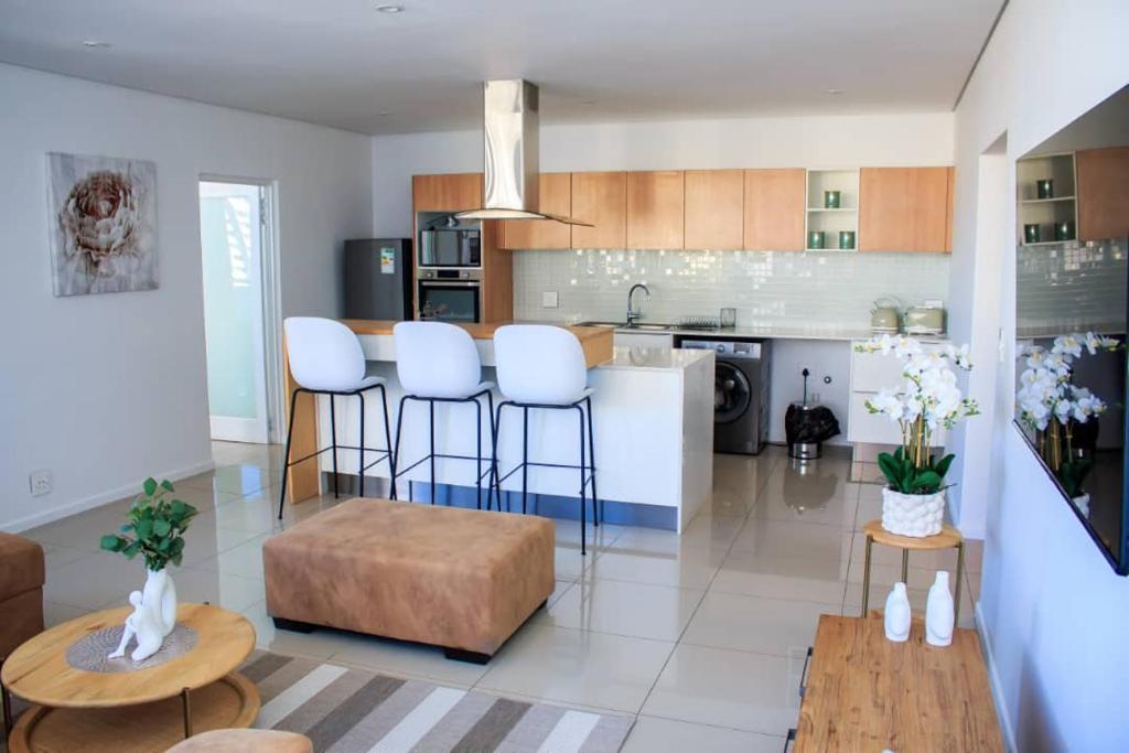 a kitchen with a counter and stools in a room at Freedom Plaza serviced apartments in Windhoek