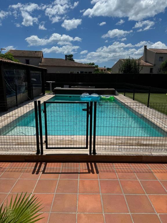 une piscine entourée d'une clôture dans l'établissement La perle rare, au Grau-dʼAgde