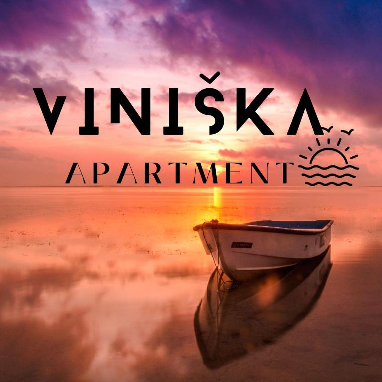 a boat sitting in the water with a sunset at Apartment Viniška in Vinišće