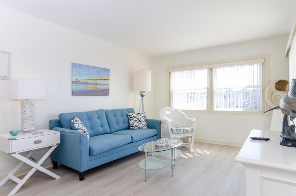a living room with a blue couch and a table at Shearin by Bryant Real Estate in Wrightsville Beach