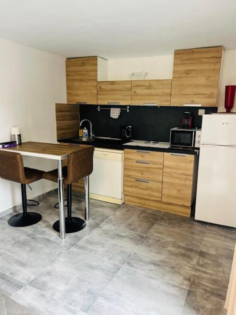 une cuisine avec une table et un réfrigérateur blanc dans l'établissement Cavalière studio 2 pers terrasse, au Lavandou