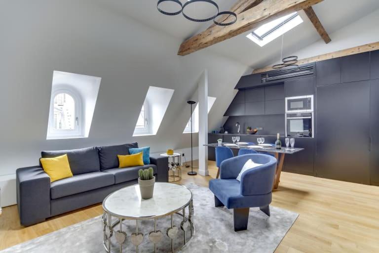 un salon avec un canapé bleu et une table dans l'établissement Elegant Home 2BDR 6P Near Champs Elysées, à Paris