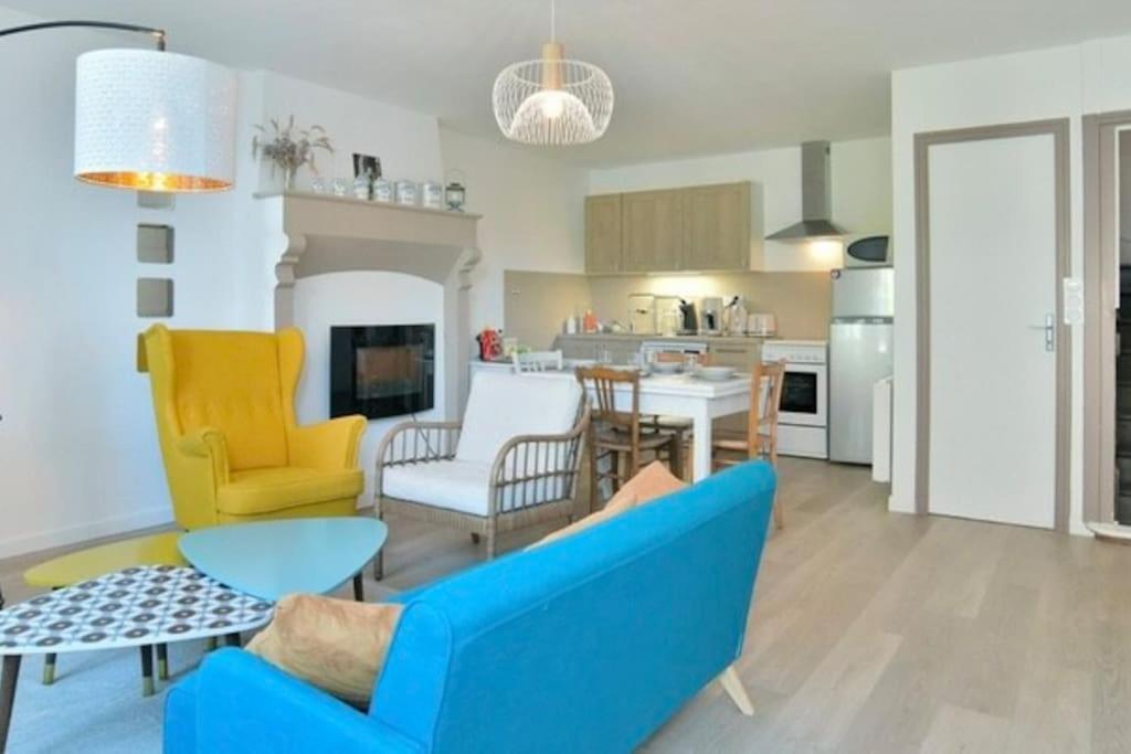 - un salon avec un canapé bleu et des fauteuils jaunes dans l'établissement Séjour Bucolique Sur les Bords de Rance, à Pleudihen-sur-Rance