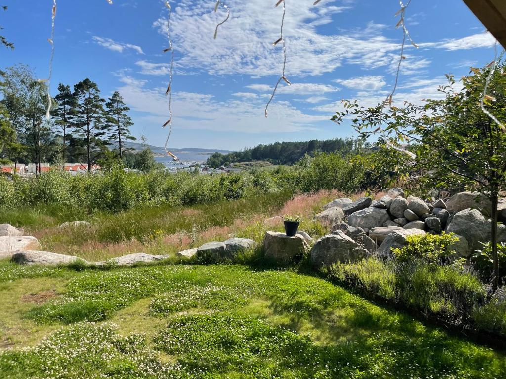 a yard with rocks and a field of grass at Ny lägenhet på markplan med havsutsikt in Strömstad