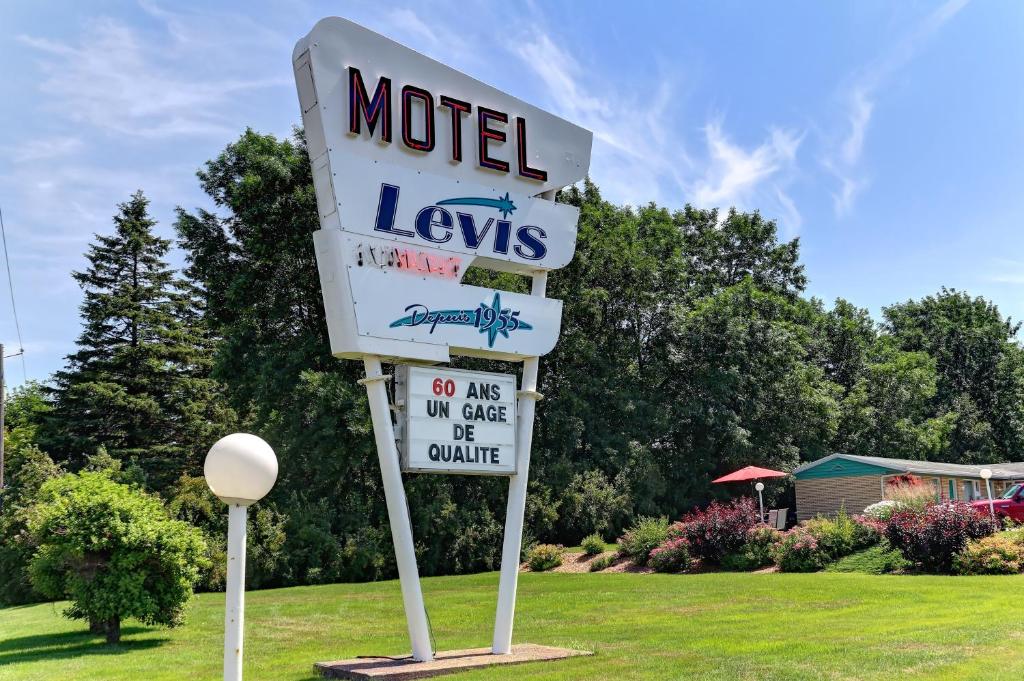 ein Schild für ein Motel Levis auf einem Rasen in der Unterkunft Motel Lévis in Lévis