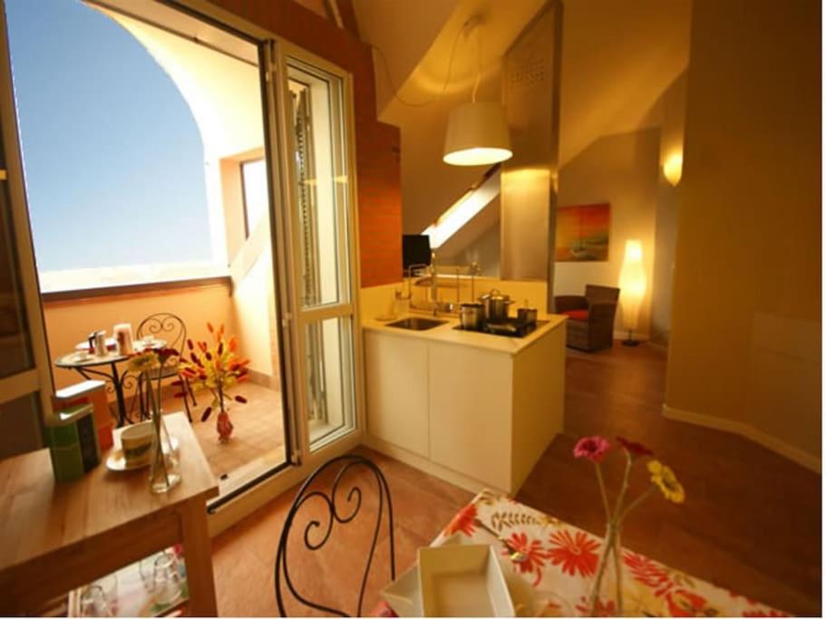 a large room with a kitchen and a large window at Sinfonia Tintoretto Central 2-Room-Flat in Verbania