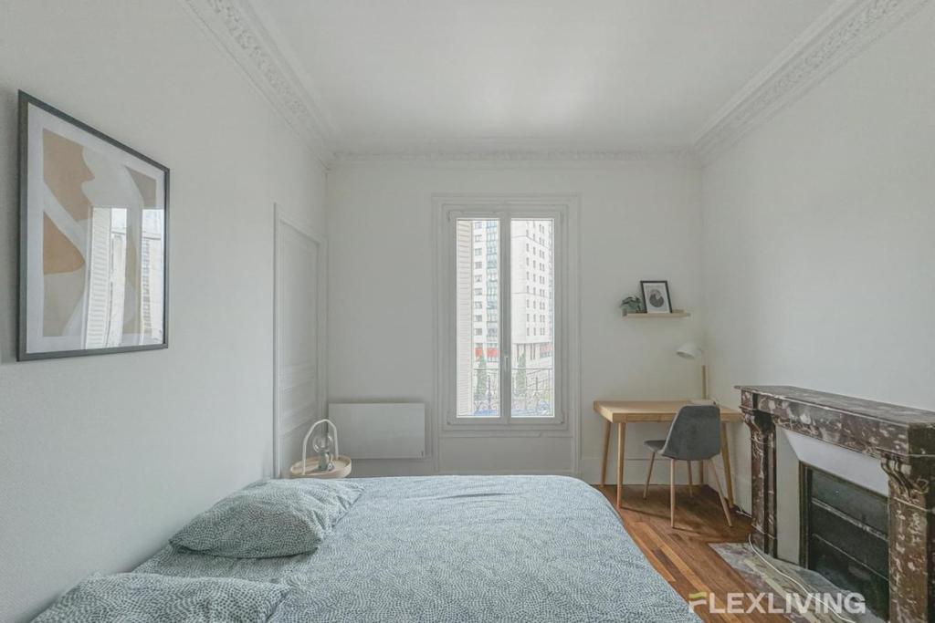 a white bedroom with a bed and a fireplace at Flexliving - Room - Henri Sellier - Suresnes 92 in Suresnes