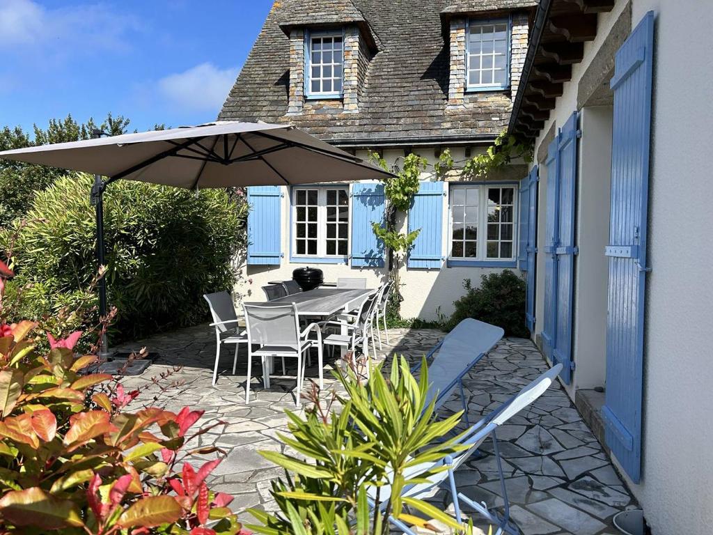 un patio avec un parasol, une table et des chaises dans l'établissement 764 - Belle maison de caractère pour 8 voyageurs, à Erquy