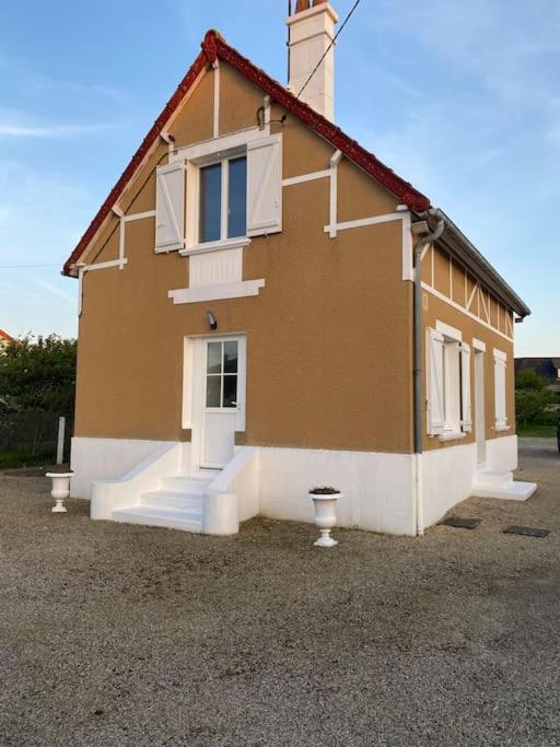 une petite maison avec des escaliers en face de celle-ci dans l'établissement Maison de vacances en bord de mer Gold Beach, à Asnelles