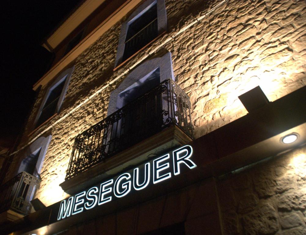 a sign on the side of a building with a balcony at Aparthotel Meseguer in Alcañiz