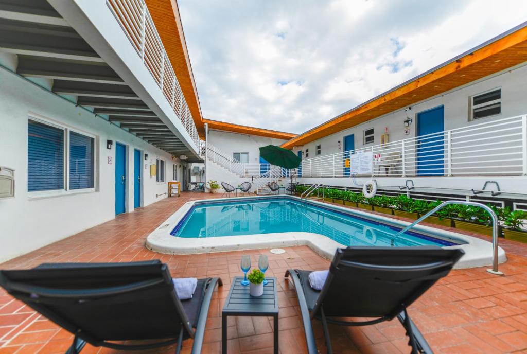 a swimming pool in a house with two chairs and a table at Family Friendly Beach Escape with pool and parking - M41 in Hollywood