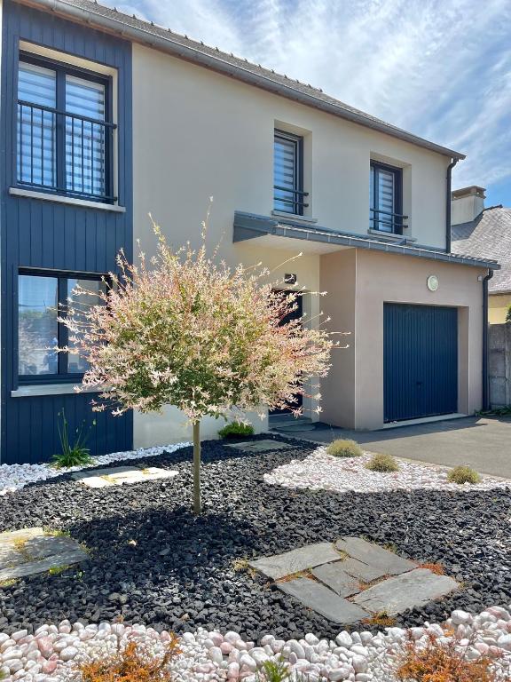 une maison avec un arbre dans la cour avant dans l'établissement Les Dunes, Maison proche plage, à Saint-Lunaire