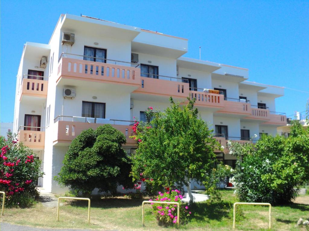 a pink and white building with trees in front of it at Thodorou Villa in Agia Marina Nea Kydonias