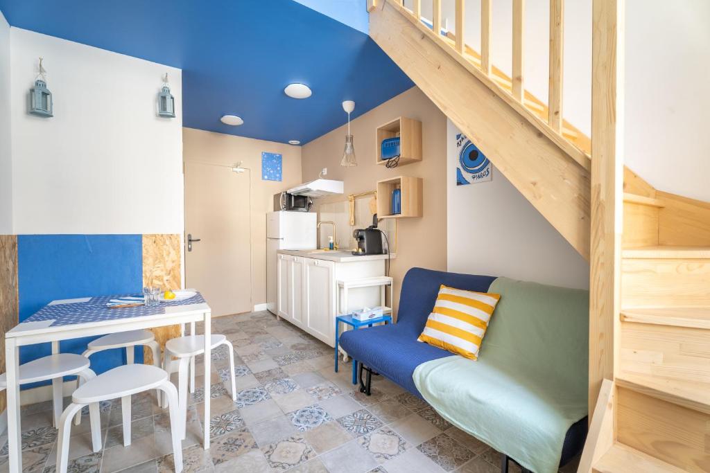 - un salon avec un canapé, une table et un escalier dans l'établissement Athènes olympe Bleu, à Marseille