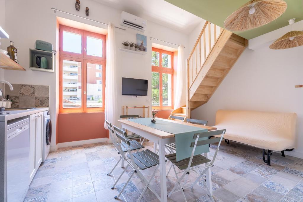 a kitchen with a table and chairs in a room at Marseille soleil urbain in Marseille