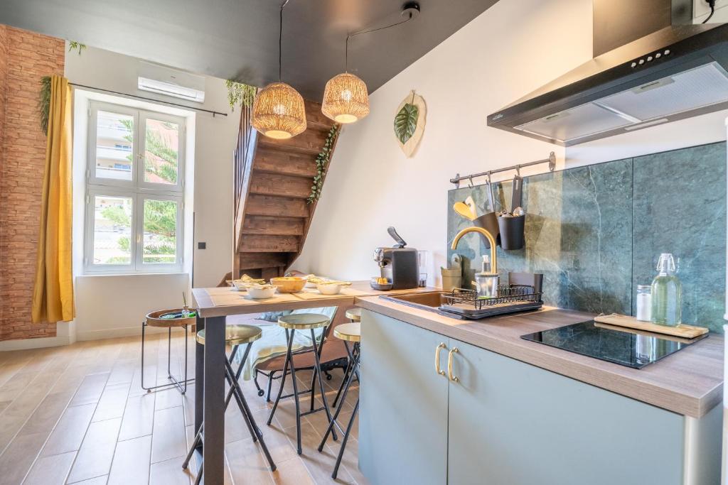 une cuisine avec un comptoir et une table avec des tabourets dans l'établissement Le Ubud Goa cosy, à Marseille