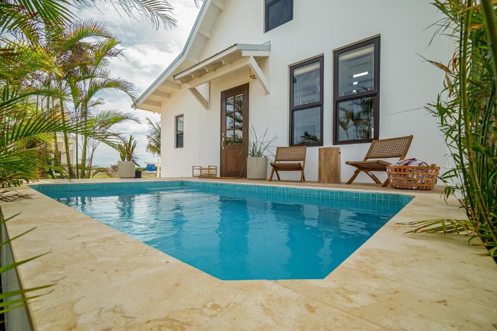 a swimming pool in front of a house at Coral Retreat and Pool Club at Mahogany Bay in San Pedro