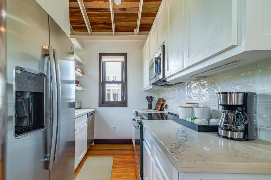 a kitchen with white cabinets and stainless steel appliances at Coral Retreat and Pool Club at Mahogany Bay in San Pedro