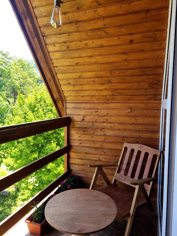 a wooden cabin with a table and a chair on a porch at Hooni_guesthouse in Odzun