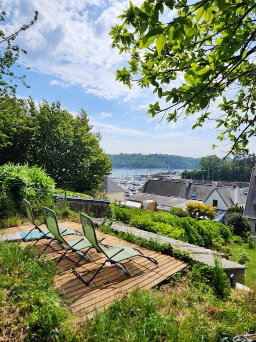 deux chaises et une terrasse en bois avec vue sur l'eau dans l'établissement Maison familiale sur le port, à Lézardrieux