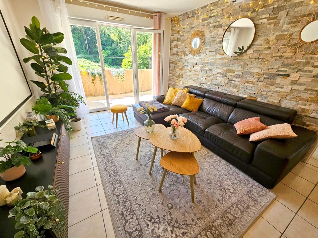 Una sala de estar con un sofá de cuero negro y una mesa. en Appartement Exceptionnel proche Centre-Ville, en Bayona