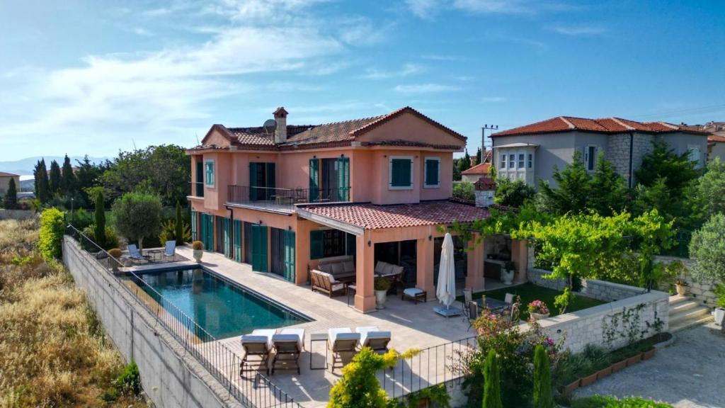 a villa with a swimming pool and a house at Viento Villa in Cesme