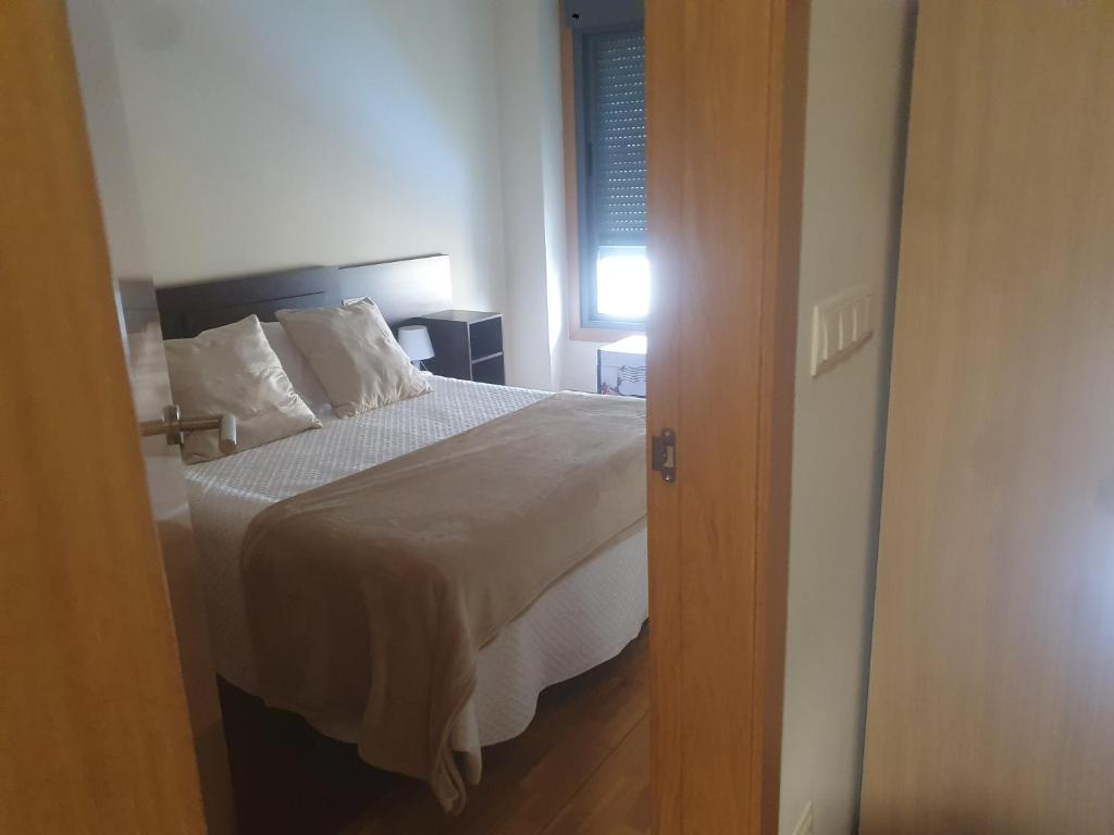 A bed or beds in a room at Apartamento en urbanización con piscina en Playa de Silgar