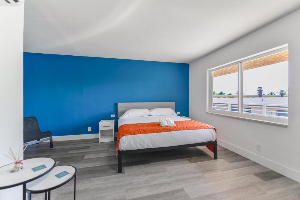 a bedroom with a bed with a blue wall at Amazing unit with pool & parking at the beach - M35 in Hollywood