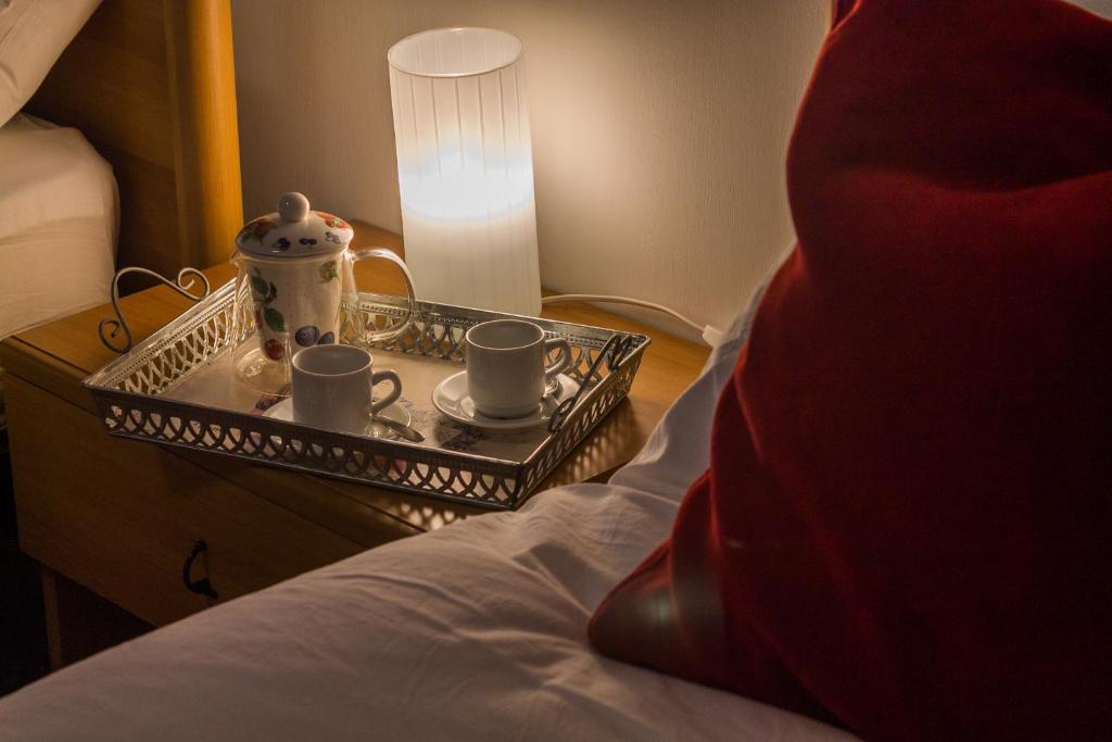 bandeja con tazas y set de té en una cama en Zamboni Apartment, en Bolonia