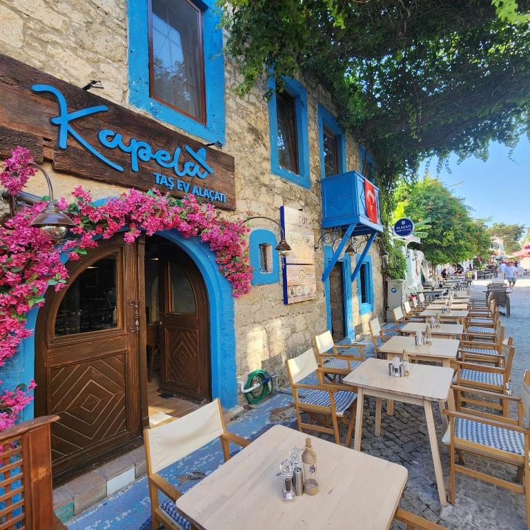 a row of tables and chairs outside of a restaurant at Kapela Taş Otel Alaçatı in Çeşme