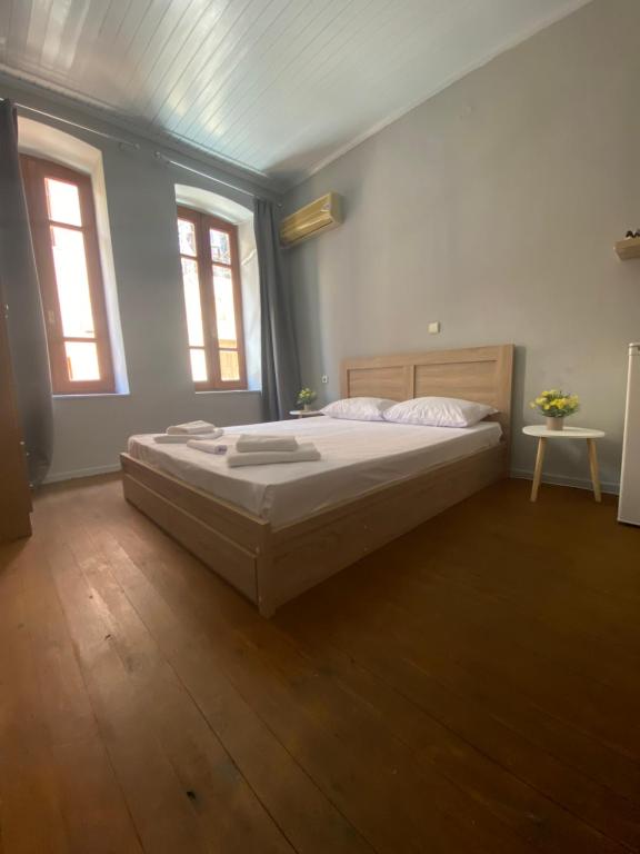 a bedroom with a large bed and two windows at spla apartments 3 , Διαμέρισμα στην πόλη των Χανίων in Chania Town